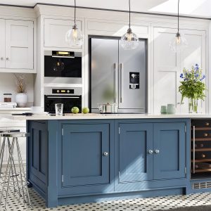 Modern style kitchen with white cabinets, blue island cabinets, and white countertops.