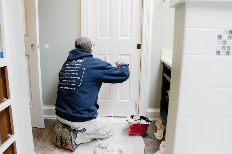 Professional painter rolling a bathroom door.