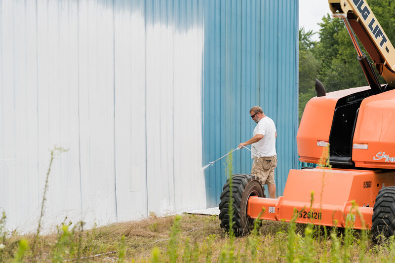 Professional Painter spraying the outside of a commercial building