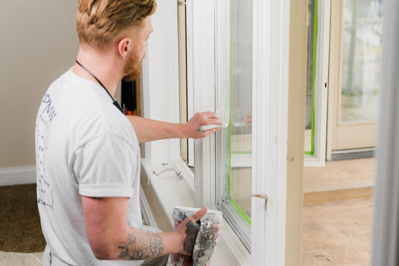 Professional painter painting trim with a brush.