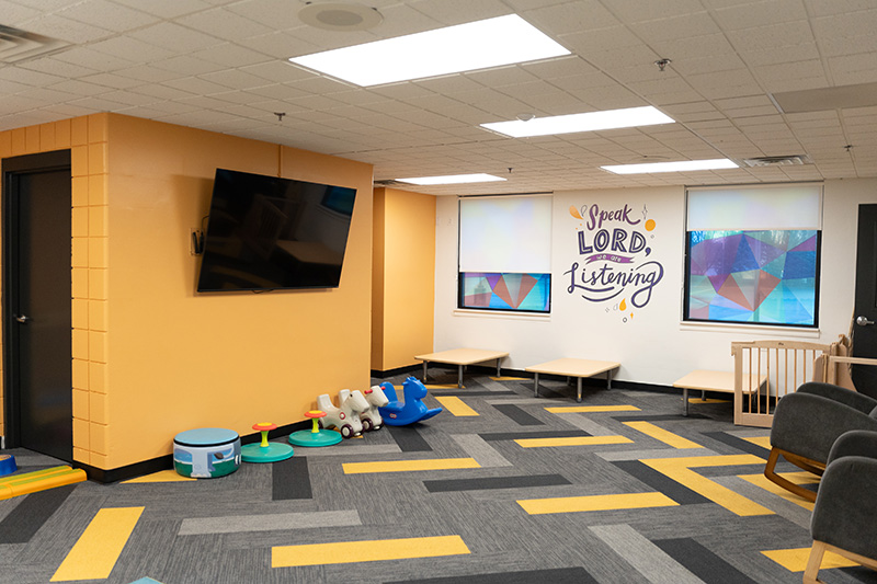 Yellow toddler room at church. Says "speak lord, we are listening" on the wall.