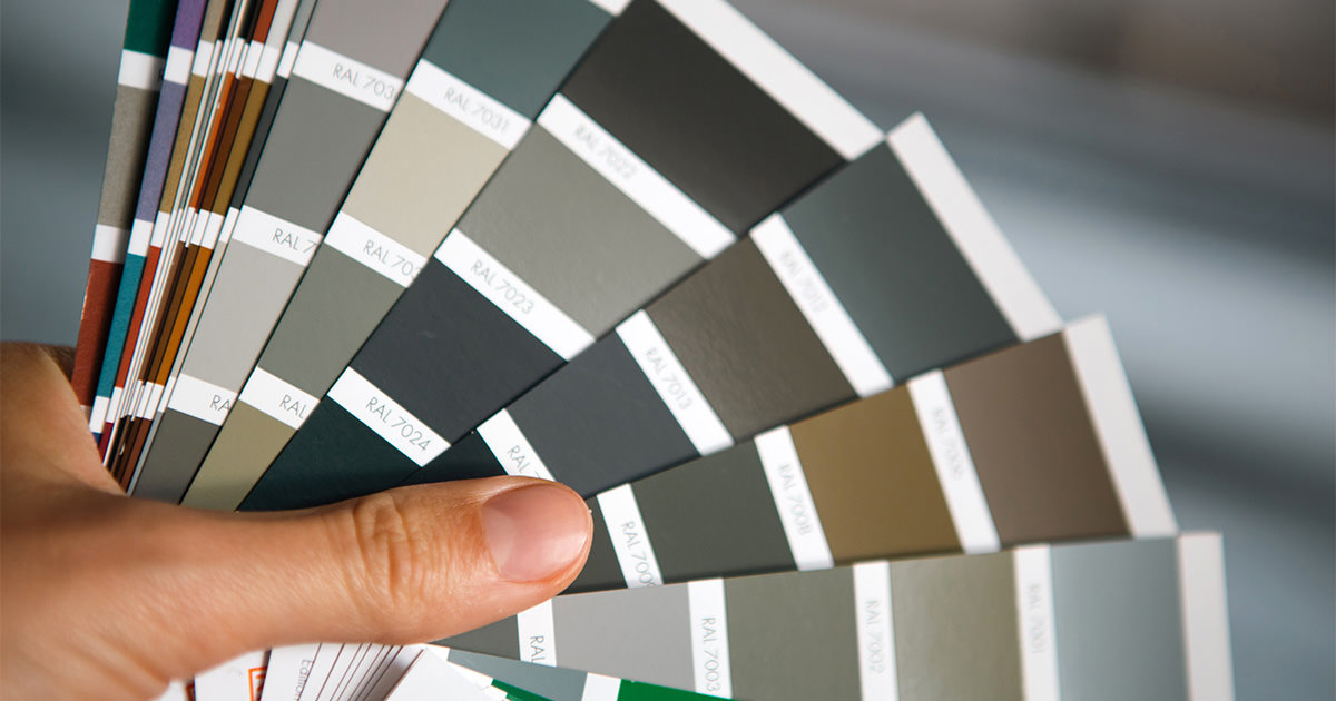 How To Choose A Kitchen Cabinet Color Tips From A Designer Image 8 person holding paint swatch booklet.