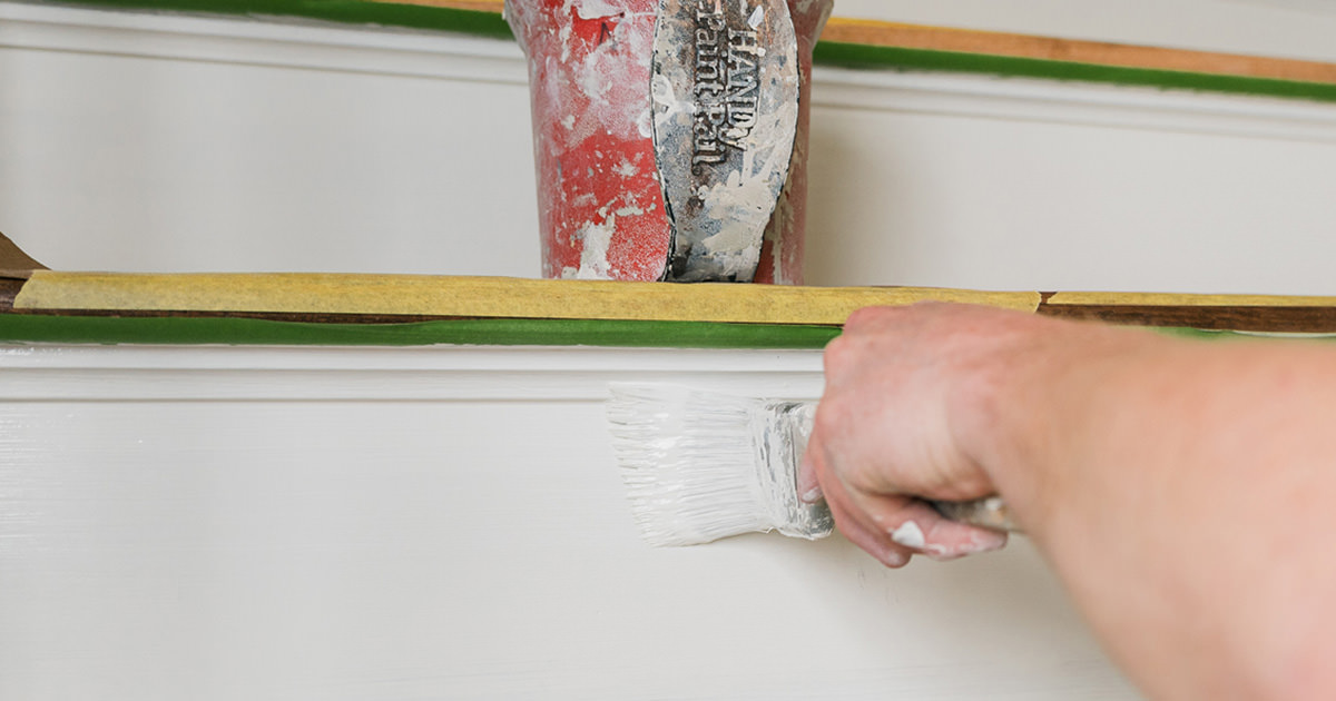 PMV - Blogs - Yes You Always Need Two Coats of Paint Header Person painting white paint on a stair risers.
