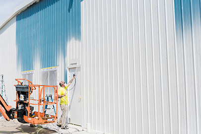 PMV - Project Highlight - Kalamazoo Valley Gleaners 4 PMV painters painting the exterior of a commercial building