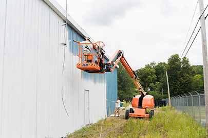 PMV - Project Highlight - Kalamazoo Valley Gleaners 5 PMV painters painting the exterior of a commercial building