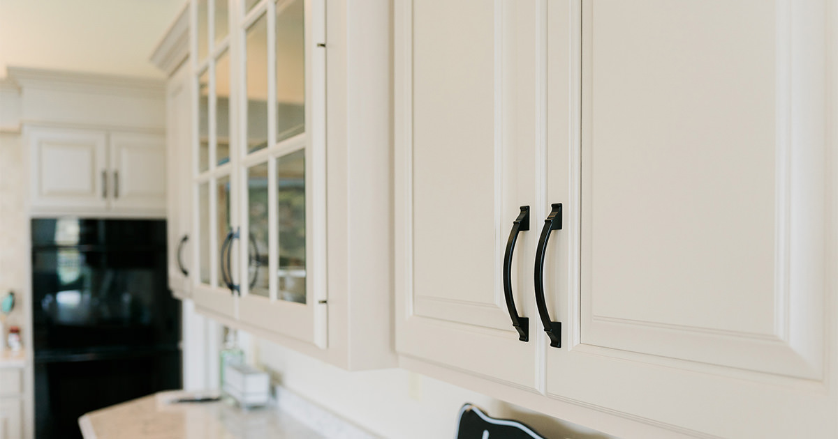PMV - Project Highlight - Lake Templene Kitchen 1 Light tan kitchen cabinets with black handles.