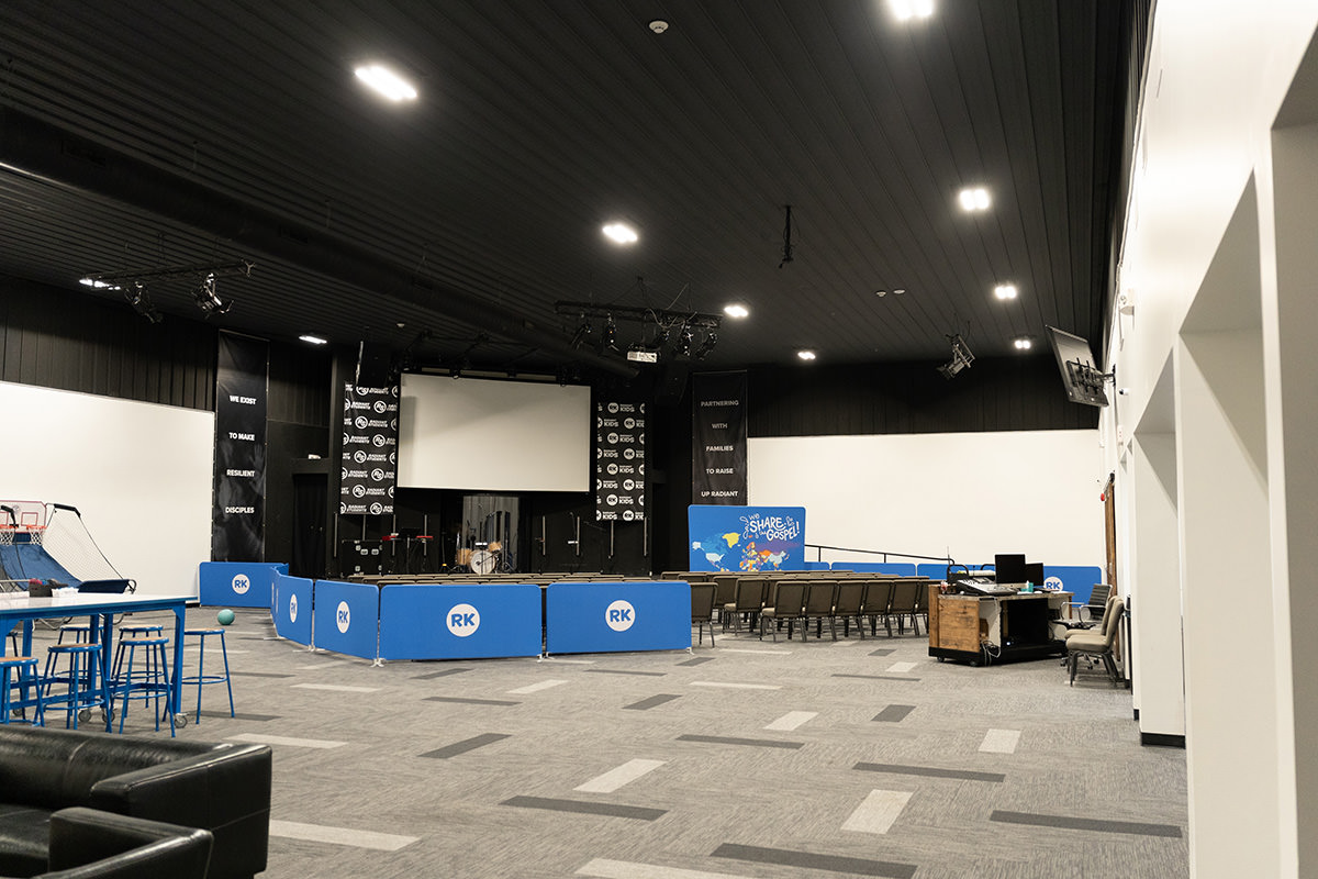 PMV - Project Highlight - Radiant Church Richland Campus Large youth room at a church with a stage and large screen.