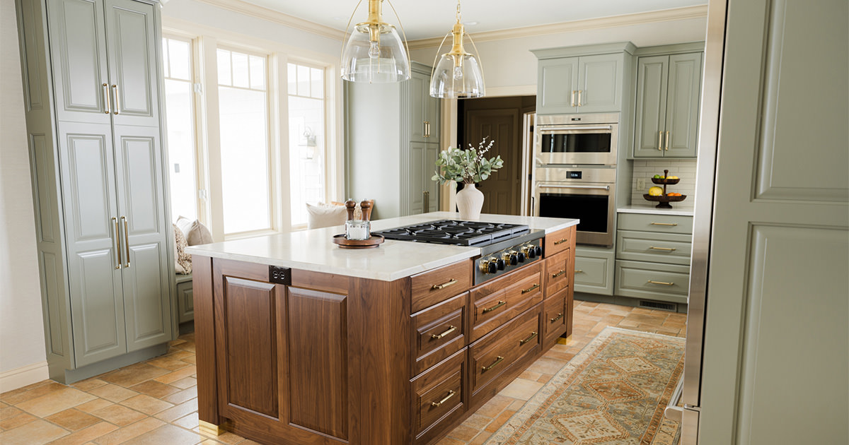 PMV - Project Highlight - French-Inspired Interior - Header Kitchen with freshly painted green cabinets and stunning wooden island.