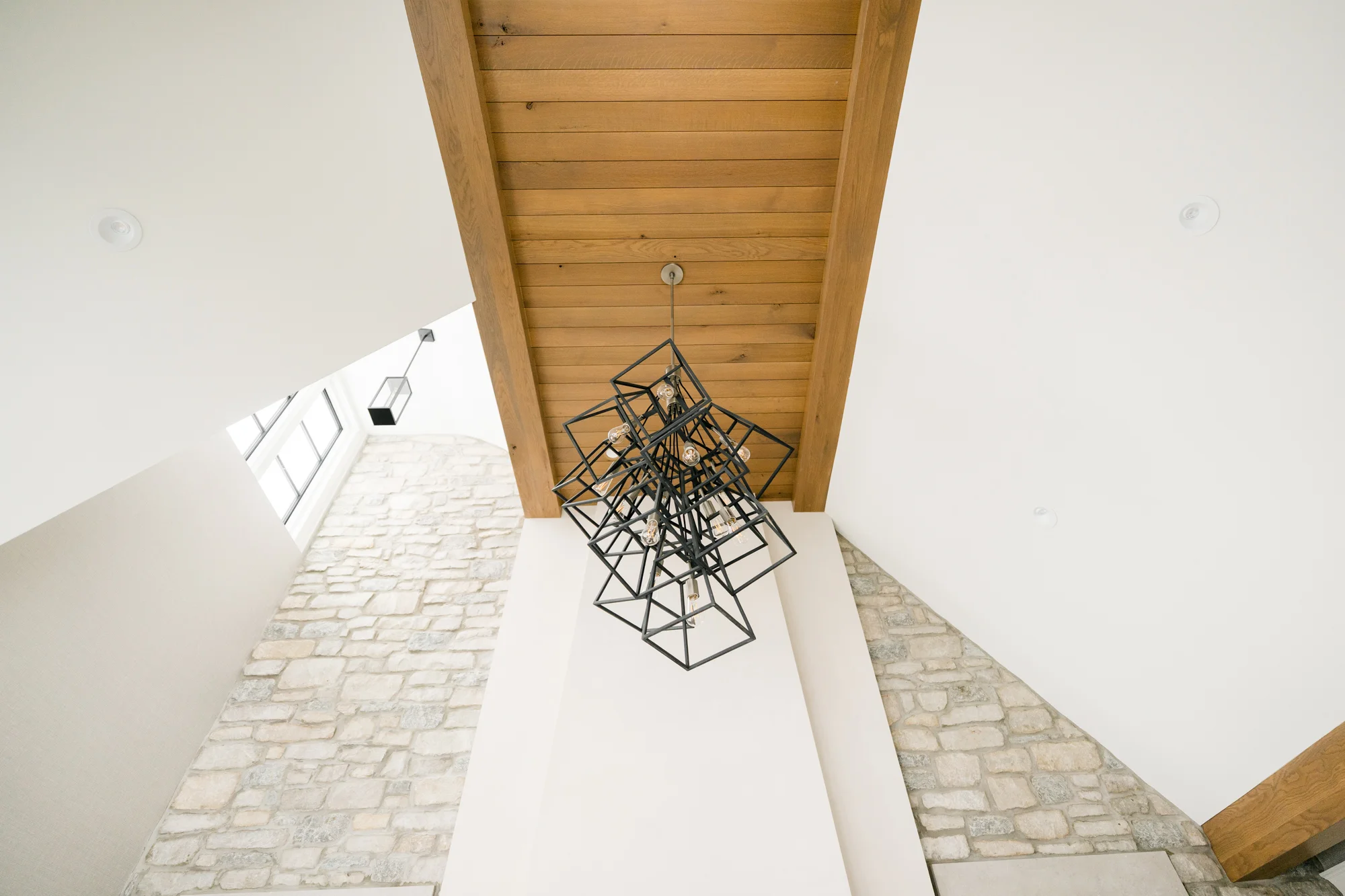 Ceiling beams and chandelier highlighting smooth painted surfaces in high-end Kalamazoo home