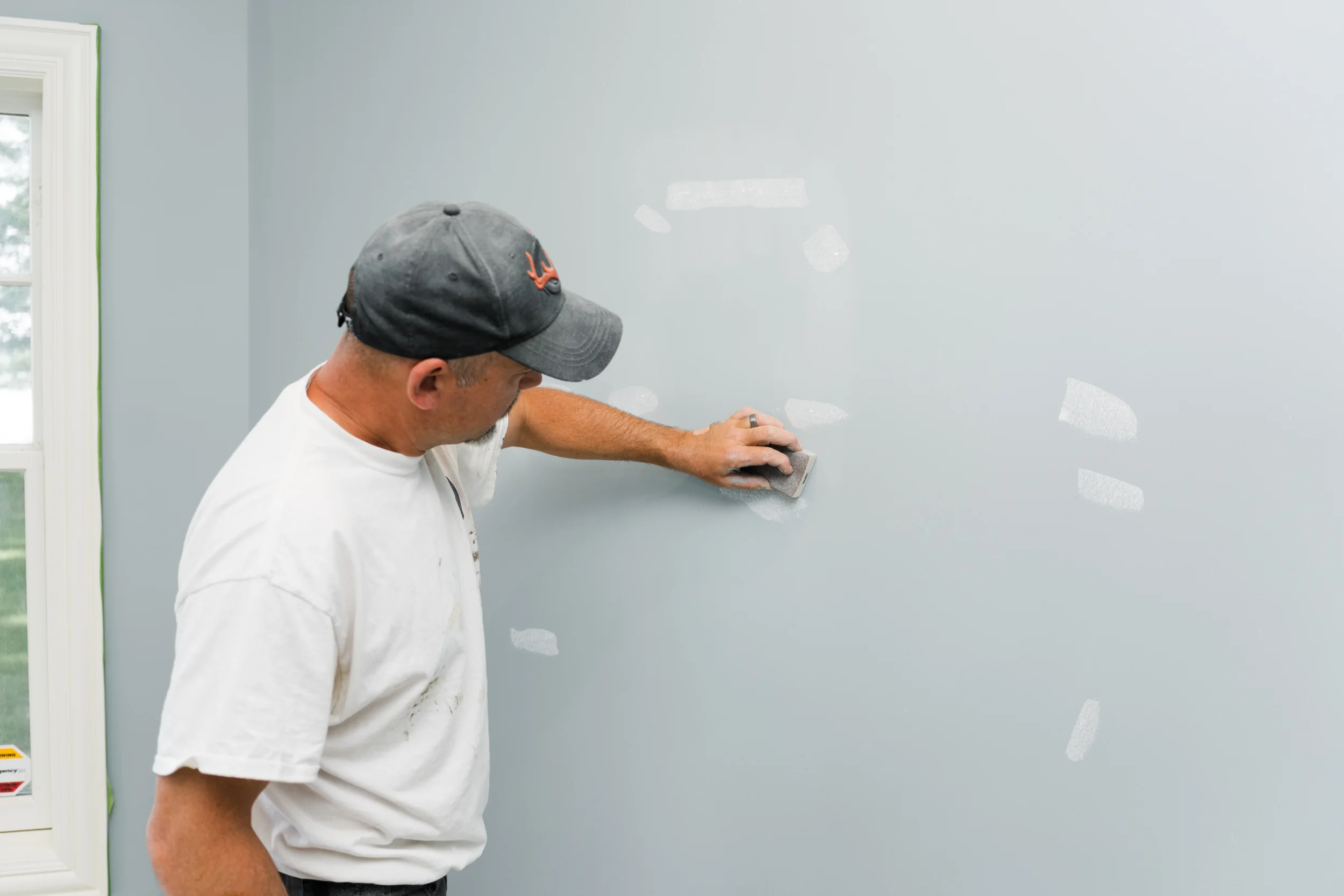 Professional sanding and surface preparation for painting in a high-end Michigan home.