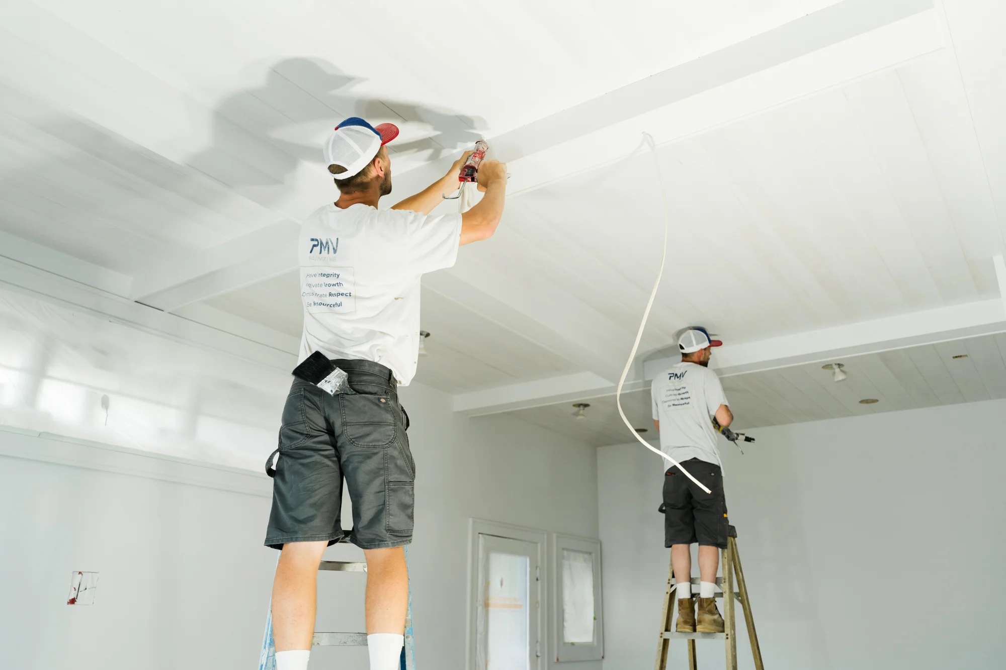 Two PMV Painting team members working together to complete a commercial painting project with minimal disruption.