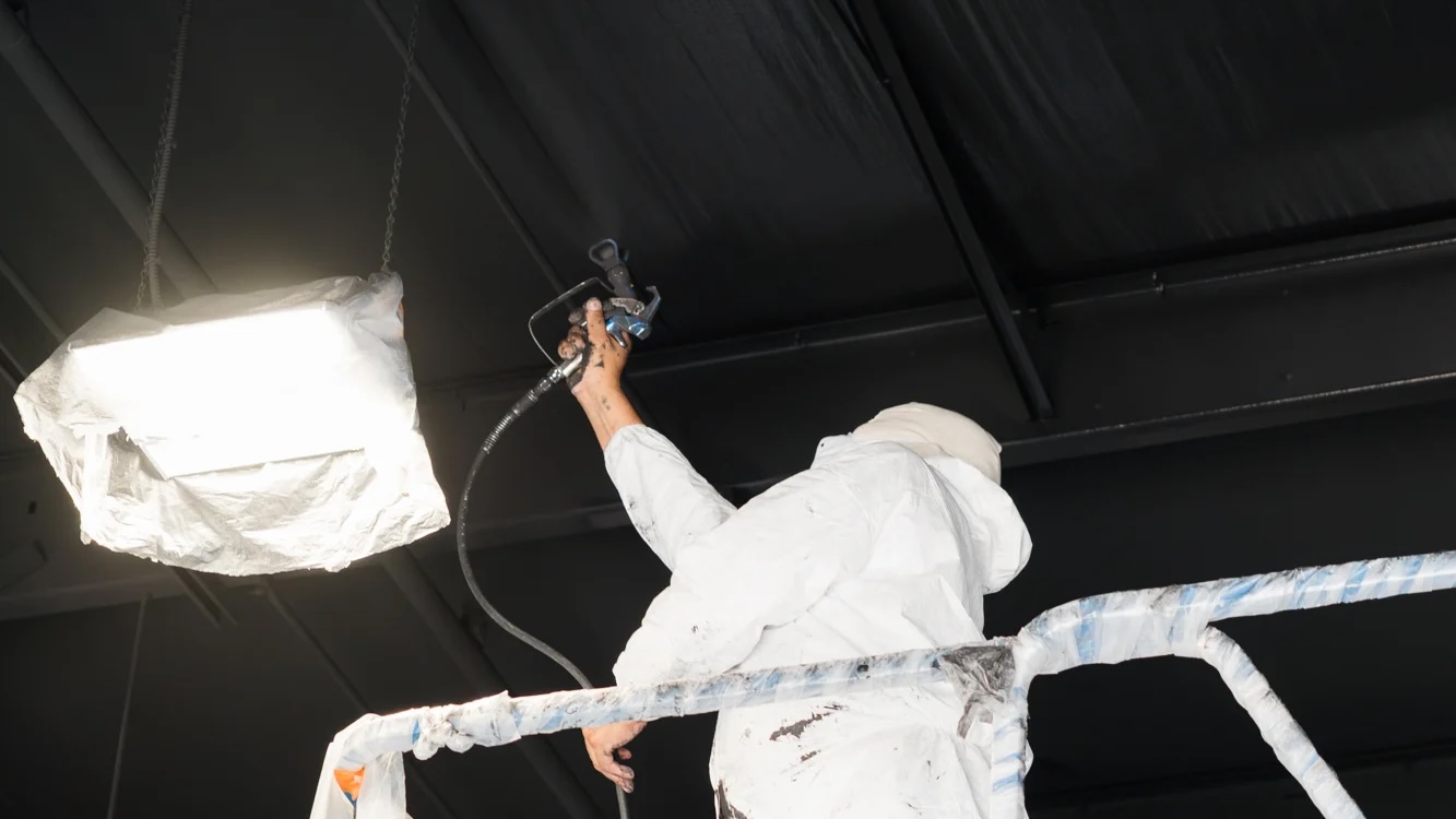 PMV painter applying a commercial coating to the ceiling at a Toyota dealership